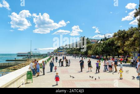 Aluschta, RUSSLAND - 15. MAI 2016: Touristen gehen entlang der Promenade in der Ferienstadt Aluschta auf der Krim. Stockfoto