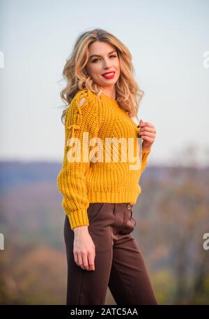 Wunderschöne Dame, die sich im Pullover aus Wolle gemütlich fühlt. Trendige Kleidung. Frau warmer Pullover Natur Hintergrund entschärft. Elegance Konzept. Schickes Mädchen Make-up Gesicht tragen Strickpullover. Stil ist ein Begriff des Gleichgewichts. Stockfoto