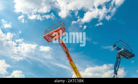 Kirschpflücker auf blauem Himmel Hintergrund. Ausleger mit Hubeimern schwerer Maschinen. Panorama der Bahnsteige der Teleskop-Aufzüge in su Stockfoto