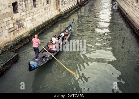 Venedig, Italien - 21. Mai 2017: Gondeln mit Touristen fahren entlang des schmalen Kanals unter der berühmten Brücke von Sighs in der Nähe des alten Gefängnisses am Doge's Stockfoto