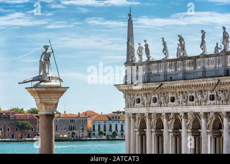 Markusplatz in Venedig, Italien. Alte Statue von St. Theodore und Bibliothek von St Mark's. San Marco (Markusplatz) ist der wichtigste Reiseattraktivist Stockfoto