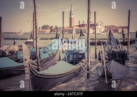 Alter Liegeplatz mit Gondeln in der Nähe des Markusplatzes, Venedig, Italien. Lagune von Venedig. Gondel ist ein traditioneller romantischer Transport in Venedig. Romantisches Wasser t Stockfoto