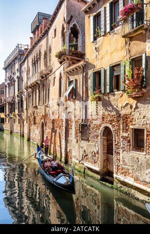 Venedig, Italien - 21. Mai 2017: Gondel fährt entlang der alten Straße mit alten Häusern in Venedig. Die Gondel ist ein attraktivster Touristentransport Venedigs. Stockfoto