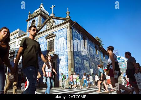 Porto, Portugal: Die Menschen gehen an den blauen azulejo-schmückten Wänden der Capela das Almas Kapelle vorbei. Stockfoto