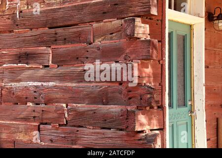 Eine rote Blockhütte mit grüner Tür Stockfoto