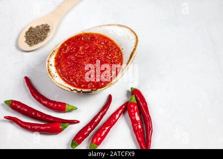 Heiße Chili Pfeffer Soße Paste Harissa. Adjika. Traditionelle Tunesien-Küche, georgische und arabische Küche. Horizontale Ausrichtung. Hausgemachte Roseharissa Stockfoto