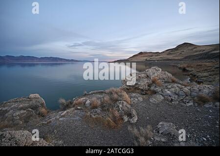 Felsformationen und Reflexionen des Pyramid Lake, Nevada am klaren, ruhigen Winternachmittag. Stockfoto
