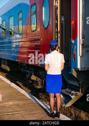 Stewardess trägt Uniform auf Bahnsteig neben dem Transsibirischen Eisenbahn-Express-Zug, der Mongolia, Asien Stockfoto