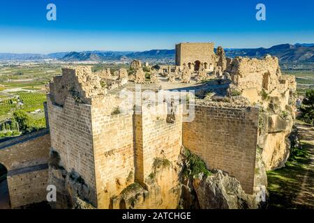 Luftaufnahme des mittelalterlichen zerstörten Montesa-Burgzentrums der Ritter der Templer- und Montesa-Orden mit Donjon, lange Rampe zum Burgtor in Spanien Stockfoto