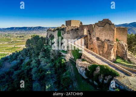 Luftaufnahme des mittelalterlichen zerstörten Montesa-Burgzentrums der Ritter der Templer- und Montesa-Orden mit Donjon, lange Rampe zum Burgtor in Spanien Stockfoto