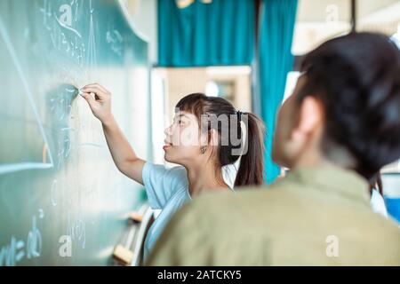 Gruppe von Studenten, die an dem mathematischen Problem arbeiten Stockfoto