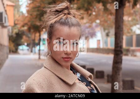 Schöne blonde Frau mit blauen Augen, mit dem Haar oben auf die Kamera blickt Stockfoto