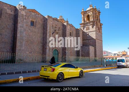 Der gelbe Toyota Celica TRD parkte vor der Dombasilika von St. Charles Borromeo, Puno, Peru Stockfoto