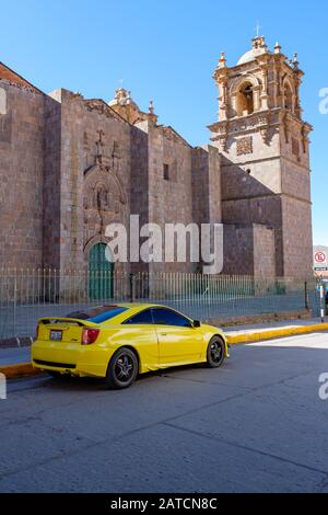 Der gelbe Toyota Celica TRD parkte vor der Dombasilika von St. Charles Borromeo, Puno, Peru Stockfoto