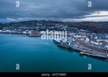 Die große Drohne schießt über den malerischen Hafen mit Fährhafen von Oban in Schottland Stockfoto