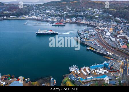 Abfahrt mit der Fähre - Drohnenschießen über den malerischen Hafen der Stadt Oban in Schottland Stockfoto