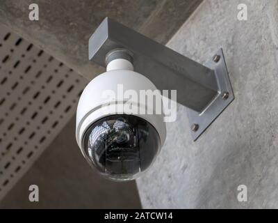 CCTV-Überwachungskamera im Flughafenterminal. Überwachungskamera zur Überwachung von Personen hängt an der Wand des Gebäudes. Menschen im Saal beobachten. Stockfoto