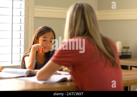 Lehrerin Hilft Ihren Schülern Bei Der Hausaufgabe Schularbeit. Stockfoto