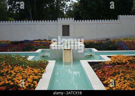 Wasserbrunnen umgeben von bunten Blumen in den Hamilton Gardens, Neuseeland Stockfoto