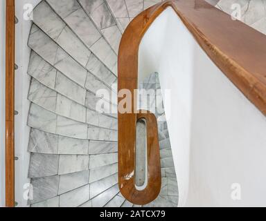 Hohe Winkelaufnahme einer weißen Treppe mit braunem Holz Geländer Stockfoto