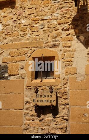 Maison Kommune, Schild und Fleur de lys. Details der Wände der Häuser aus goldenen Steinen in der schönen mittelalterlichen Stadt Oingt France Stockfoto