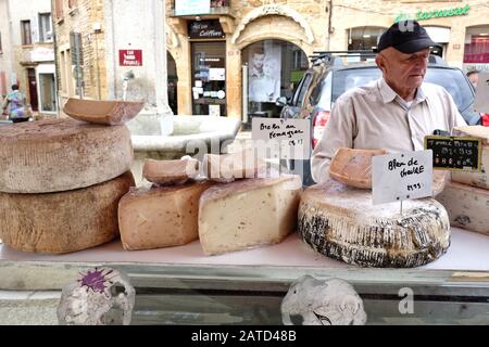 Große große Käseräder ein Käseherman bei den lokalen frischen Produkten, die auf dem französischen Straßenmarkt im Freien in Le Bois-d'Oingt zum Verkauf angeboten werden Stockfoto