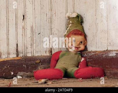 Eine raggierige, zerfetzte, alte rote und grüne Elf-Puppe in einem heruntergekommenen verlassenen Haus in der Nähe von Springfield, Georgia. Stockfoto