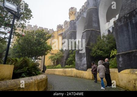 Sintra, Portugal - 18. Januar 2020: Touristen machen Fotos vom Pena Palast bei extrem nebligen Wetterbedingungen im Winter Stockfoto