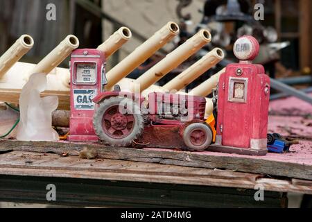 Ein Toy Farmall Traktor, mit Spielzeug-Gaspumpen, ein im Gebet kniender matter Glasangel, mit einem Rack elektrischer Weihnachtskerzen ohne Glühbirnen Stockfoto