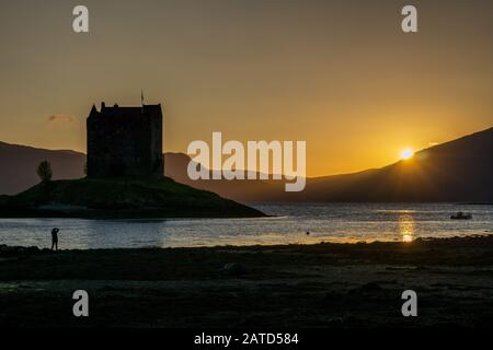 Sonnenuntergang über Castle Stalker ist ein vierstöckiges Tower House oder malerisch auf einer Gezeitenislet am Loch Laich, einem Zufluss am Loch Linnhe, aufgestellt. Es ist abou Stockfoto
