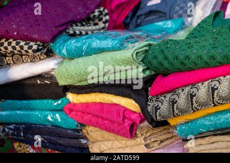 Selektive Konzentration auf verschiedene Stoffe, die an einem Stand in Surajkund Crafts Mela in Indien zum Verkauf angeboten werden Stockfoto