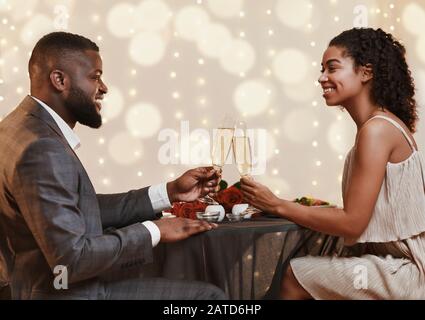 Junges schwarzes Paar trinkt Champagner für ihre Liebe Stockfoto