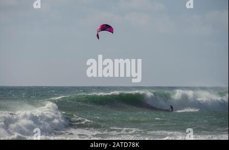 Ein Kiteboarder oder Paraborder segelt auf den kornischen Wellen. GROSSBRITANNIEN Stockfoto