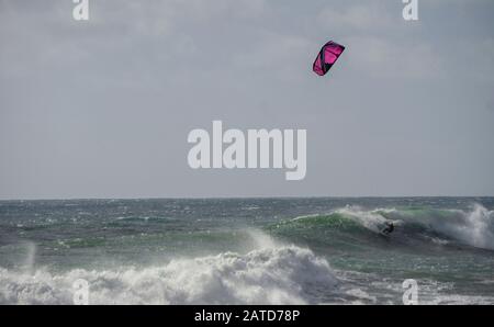 Ein Kiteboarder oder Paraborder segelt auf den kornischen Wellen. GROSSBRITANNIEN Stockfoto