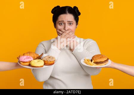 Plus Size Girl Bedeckend Mund, Ablehnung Zu Essen Angeboten Junk Food Stockfoto