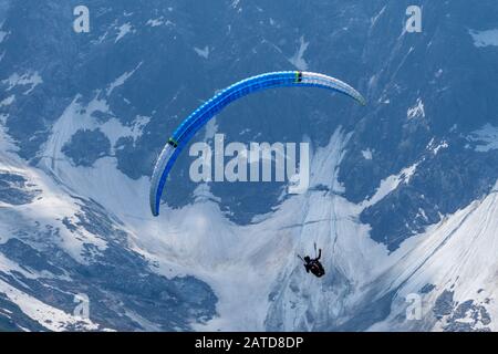 Gleitschirmflieger suchen Thermik unter den Schneekappen des Monte-Blanc-Massivs, Chamonix, Frankreich Stockfoto