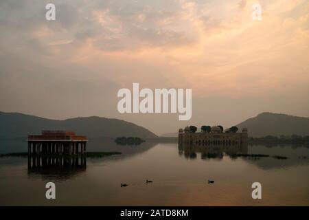 Leerer Königspalast, umgeben von See- und Aravalli-Hügeln, während die Morgendämmerung in Jaipur, Rajasthan, Indien bricht. Stockfoto