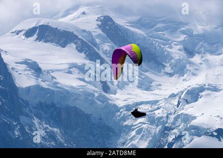 Gleitschirmflieger suchen Thermik unter den Schneekappen des Monte-Blanc-Massivs, Chamonix, Frankreich Stockfoto