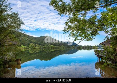 Malerisches Meer am Schliersee an einem sonnigen Tag mit blauem Himmel in Bayern, Deutschland. Cottage Stockfoto