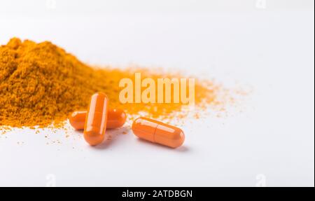 Haufen von Kurkumapseln und Pulver auf Weiß Stockfoto