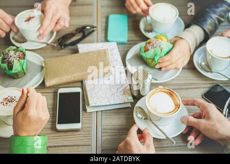 Die Leute trinken Cappuccino und essen Muffins in der Café-Bar - Junge Freunde frühstücken mit oberem Gesichtspunkt - Geselliges Konzept Stockfoto