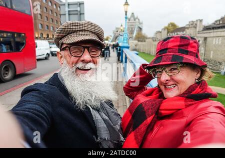 Glückliches älteres Paar, das selfie in london nimmt - Alte Trendsleute, die mit Technologietrends Spaß haben - Reise- und freudiges älteres Lifestyle-Konzept - Main Stockfoto