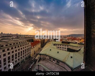 Prager Rotdächer und Türme der historischen Prager Altstadt. Das Stadtbild von Prag bei einem frostigen Sonnenuntergang. Rote Dächer, Türme und Prager Burg in der BA Stockfoto