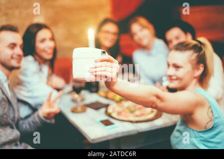 Fröhliche Freunde, die selfie mit Sofortkamera in einem trendigen Cocktailbar Restaurant einnehmen - Junge Leute, die sich vor dem Abendessen mit Vorspeise verwöhnen lassen - Youth tec Stockfoto