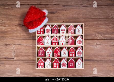 Handgefertigter Kalender aus Holz in Form eines Hauses mit weihnachtshut Stockfoto