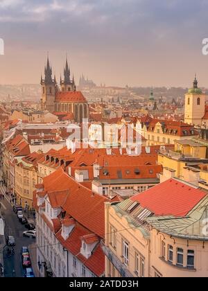 Prager Rotdächer und Türme der historischen Prager Altstadt. Das Stadtbild von Prag bei einem frostigen Sonnenuntergang. Rote Dächer, Türme und Prager Burg in der BA Stockfoto