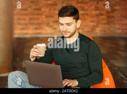 Freiberufler Guy, Der Im Modernen Coworking Workspace Am Laptop Arbeitet Stockfoto