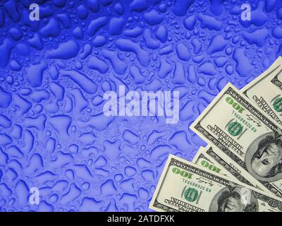 Der Haufen von Einhundert US-Dollar-Banknoten auf Verschwommenen, unscharfen, klassischen blauen, abstrakten Texturtau lässt den Hintergrund des Wassers sinken Stockfoto