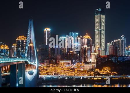 Chongqing, China - 10. Juni 2018: Skyline von Chongqing in der Nacht mit Brücke und Höhle von HongyaDong Stockfoto