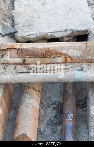 Rostige Kanalisationsrohre - Unterirdisch. Reparatur der Erdwasserversorgung, vertikales Foto. Stockfoto